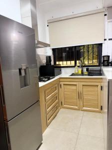a kitchen with wooden cabinets and a stainless steel refrigerator at Equinox Studio in La Gaulette +2 photos