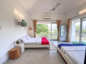 a bedroom with two beds and a balcony at NIVANTA-CREAZE by Bendre's in Kārli +217 photos