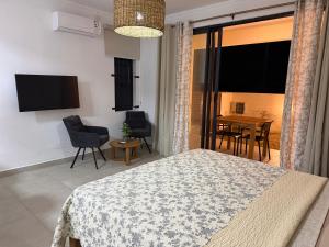 a bedroom with a bed and a table with chairs at Equinox Studio in La Gaulette