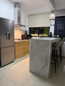 a kitchen with a stainless steel refrigerator and a counter at Equinox Studio in La Gaulette