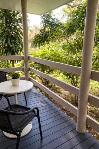 a table and a chair on a porch at Hidden Gem at The Bay - Resort Pool - 300m to Beach in Urangan +11 photos