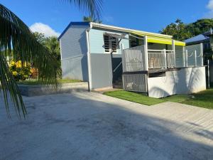 a white house with a yellow roof and a driveway at Exceptional bungalow with private pool in Rivière-Pilote