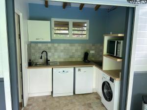 a kitchen with white cabinets and a washer and dryer at Exceptional bungalow with private pool in Rivière-Pilote