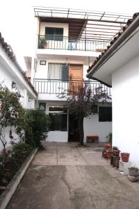 a white building with a balcony and a courtyard at Lechugal Guest House in Cusco