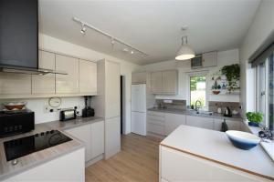 a kitchen with white cabinets and a white counter top at Ocean View in Rosscarbery +17 photos