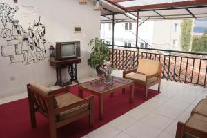 a balcony with a tv and a table and chairs at Lechugal Guest House in Cusco