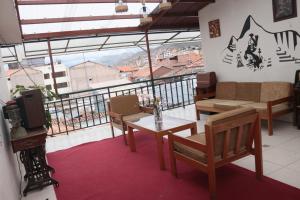 a room with a balcony with a table and chairs at Lechugal Guest House in Cusco