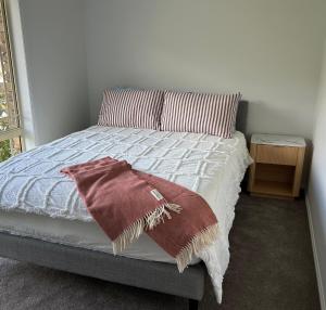 a bed with two pillows and a blanket on it at Millingtons Beach House in Orford