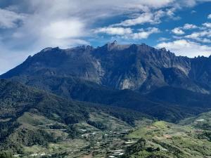 a view of a mountain with a town in front at D'TERRACE KUNDASANG in Ranau