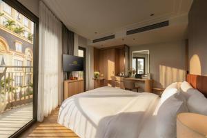 a bedroom with a large white bed and a desk at Hong Ngoc Cochinchine Boutique Hotel & Spa in Hanoi +96 photos