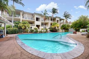 a large swimming pool in front of a building at 6 Colonial in Noosaville