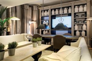 伦敦The Franklin London - Starhotels Collezione的一间配备有白色家具和电视的用餐室