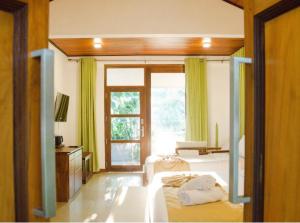 a bedroom with a bed and a large window at vainika wild sigiriya in Sigiriya