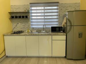 a kitchen with a refrigerator and a sink at Your modern getaway with uniquely stylish comfort in Nuevo Casas Grandes +29 photos