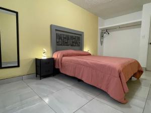 a bedroom with a bed with red sheets and a mirror at Your modern getaway with uniquely stylish comfort in Nuevo Casas Grandes