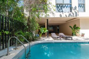 a swimming pool in front of a house at Jungle Loft Suite with Terrace & Natural Light - Santuario Hotel Boutique in Chemuyil