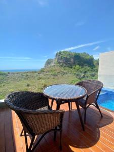 two chairs and a table on a deck with a view at HeHa Ocean Glamping dan Cabin in Ngundel