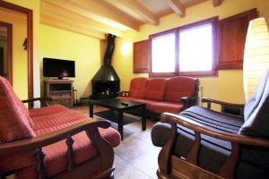 a living room with a red couch and a fireplace at Casa Rural Sant Joan in Olíus