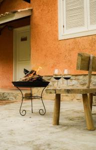 two glasses of wine sitting on a bench at Pousada do Nonno in Venda Nova do Imigrante