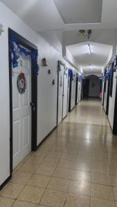 a hallway with a row of doors with blue bows at Hostal Travesía Urbana in Guadalupe