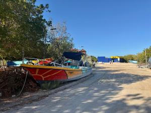 a boat sitting on the side of a road at Krak-Inn Holbox - Pet Friendly in Holbox Island