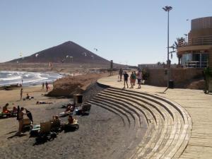 a group of people on a beach near the ocean at El Médano PlayaMar in El Médano