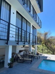a balcony with a table and chairs next to a pool at Casa Elio - Bed and Breakfast in San Juan del Sur