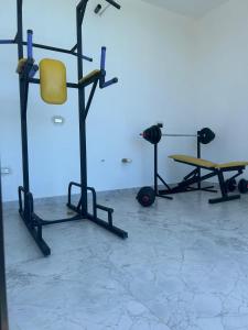 a gym with a yellow chair and two weights at Casa Elio - Bed and Breakfast in San Juan del Sur