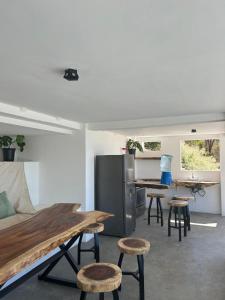 a kitchen with a table and stools and a refrigerator at Casa Elio - Bed and Breakfast in San Juan del Sur