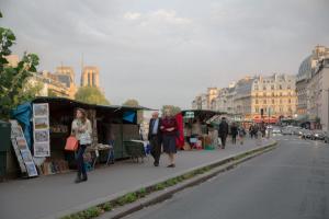 Eine Gruppe von Leuten, die mit Imbisswagen die Straße entlang laufen in der Unterkunft Le Vintage in Paris