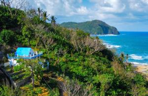 a house on a hill next to the ocean at L'Astrolabe - Ocean View Tiny House in Baras
