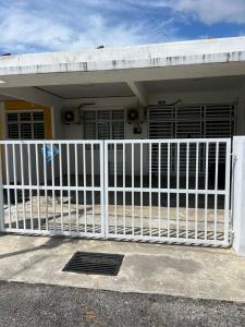a white fence in front of a house at Impian May Homestay 1,Taman Koperat Putera in Kampung Raja