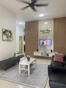 a living room with a couch and a tv at Impian May Homestay 1,Taman Koperat Putera in Kampung Raja