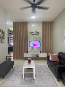 a living room with a couch and a tv at Impian May Homestay 1,Taman Koperat Putera in Kampung Raja +24 photos