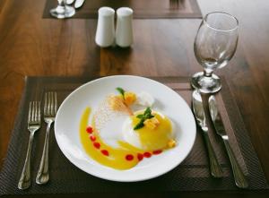 a plate of food on a table with a wine glass at vainika wild sigiriya in Sigiriya