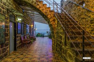 an archway in a brick building with tables and chairs at Villa Alliance in Tiberias