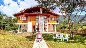 a woman standing in front of a house at Villa Amaranto Oxapampa in Oxapampa