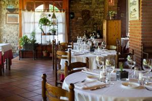 a dining room with white tables and chairs with wine glasses at Mas de la Sala in Sallent del Llobregat
