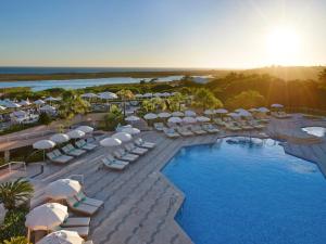 an aerial view of a resort with a pool and umbrellas at Hotel Quinta do Lago in Quinta do Lago