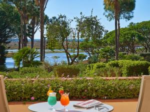 two drinks on a table with a view of the water at Hotel Quinta do Lago in Quinta do Lago