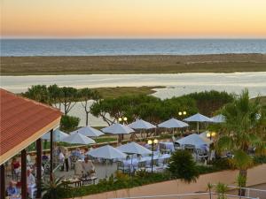 an aerial view of a beach with white umbrellas at Hotel Quinta do Lago in Quinta do Lago