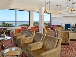 a lobby with chairs and tables and windows at Hotel Quinta do Lago in Quinta do Lago
