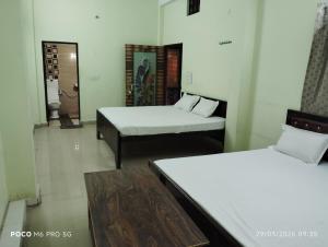 a room with two beds and a couch in it at Hotel Shri Ram Palace in Rewa