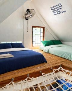 a attic bedroom with two beds and a hammock at L'Astrolabe - Ocean View Tiny House in Baras