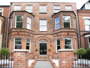 a red brick building with a black door at Queens Quarter Apartments in Belfast