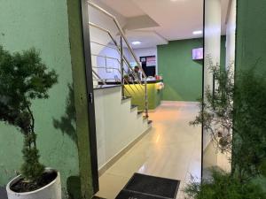 a lobby with a hallway with potted plants in a building at Hotel 44 Oliveira in Goiânia