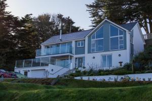 a large white house with blue windows at Holywell Bay B & B in Newquay