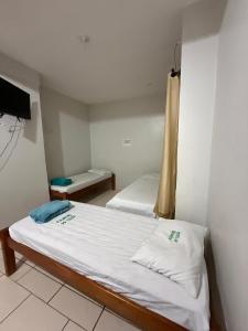 a small room with two beds and a tv at Hotel 44 Oliveira in Goiânia