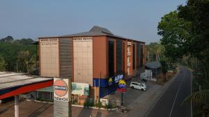 a building on the side of a road next to a street at Empire Suites in Erāttupetta