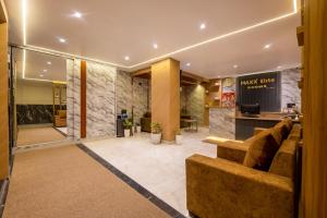 a lobby with a couch and a bar at MAXX Elite in Gurgaon